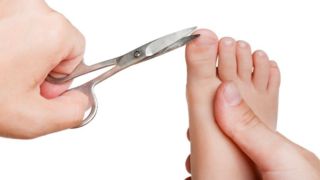 Мама обрезает ногти на ногах ребенку